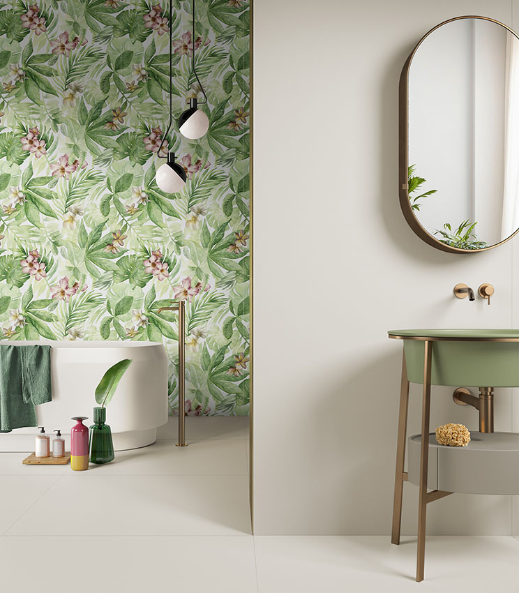 Modernes Badezimmer mit tropisch gemusterter Wand, weißer freistehender Badewanne und grünem Waschbecken mit ovalem Spiegel.