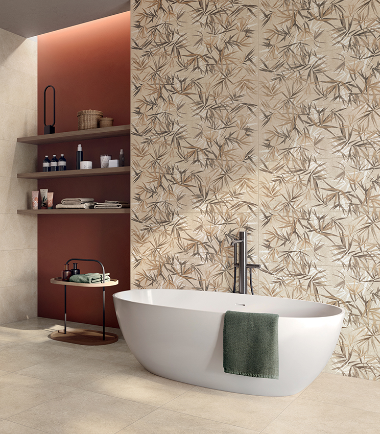 Modernes Badezimmer mit freistehender Badewanne und Oberflächen aus der Kollektion Iqoniqa von Panaria Ceramica: Das botanische Dekor Stalks Warm prägt die Hauptwand und wird mit den neutralen Farbtönen von Velvet Naturale an Boden und Wänden kombiniert.