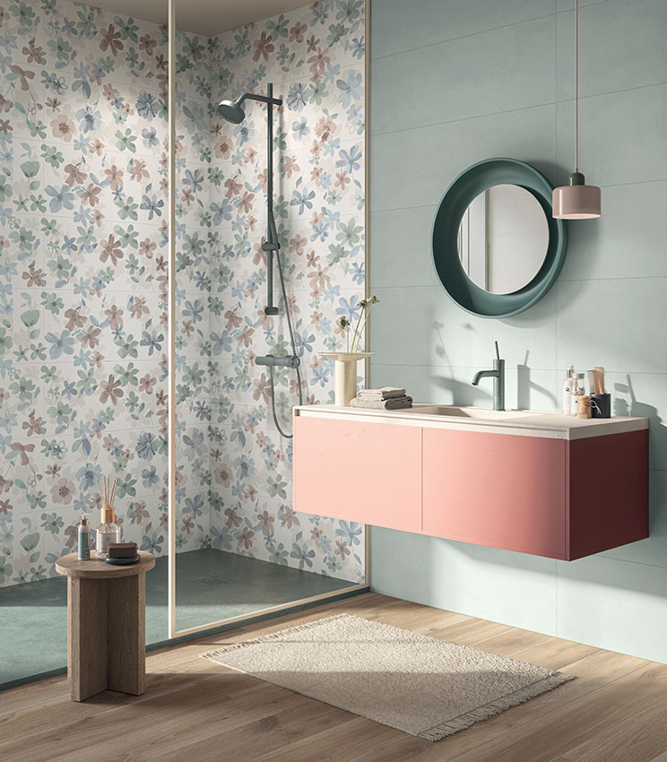 Vista frontale di una stretta parete lavabo rivestita in gres porcellanato effetto cemento, inserita in un'ampia stanza da bagno pavimentata con doghe di legno ceramico chiaro.