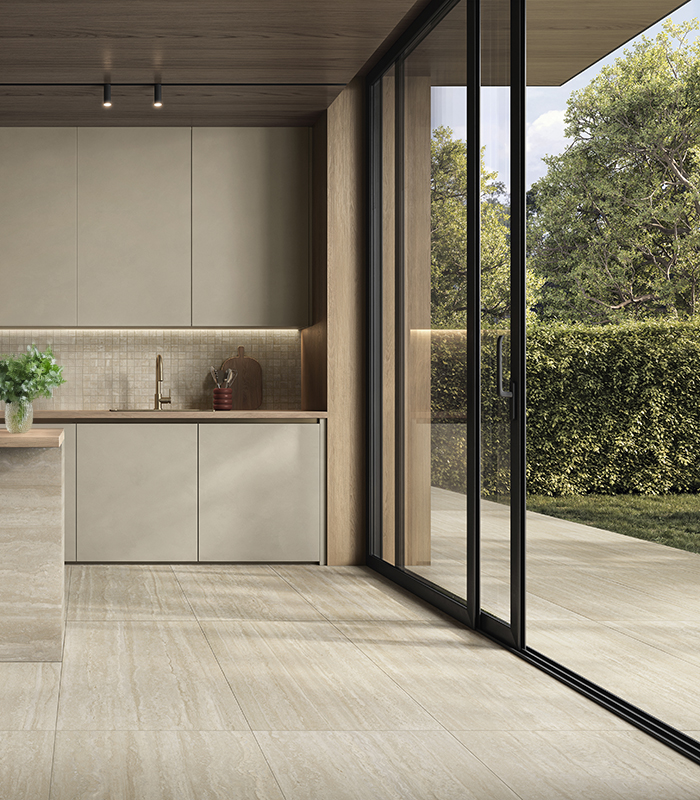 Interno cucina con pavimento in gres effetto travertino Perpetual Travertino di Panaria Ceramica, in continuità con l’outdoor.