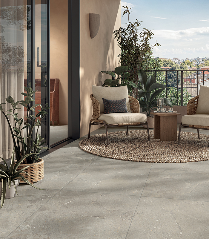 Terrazza arredata con pavimento in gres effetto pietra Revel di Panaria Ceramica, dove natura e design si incontrano.