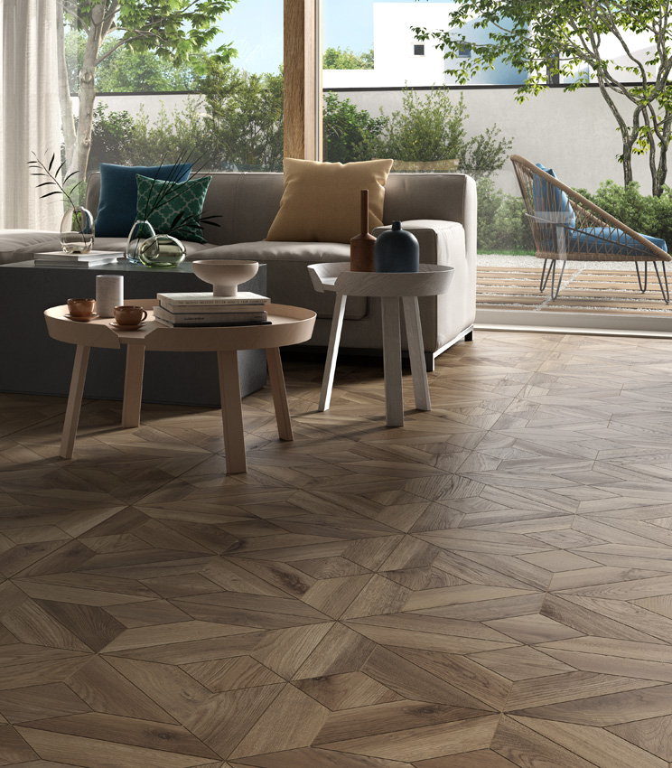 Blick in einen Wohnbereich mit großer Glasfront und zwei großen Sofas, mit einem Feinsteinzeugboden in dunkler Holzoptik in Kassettenverlegung.